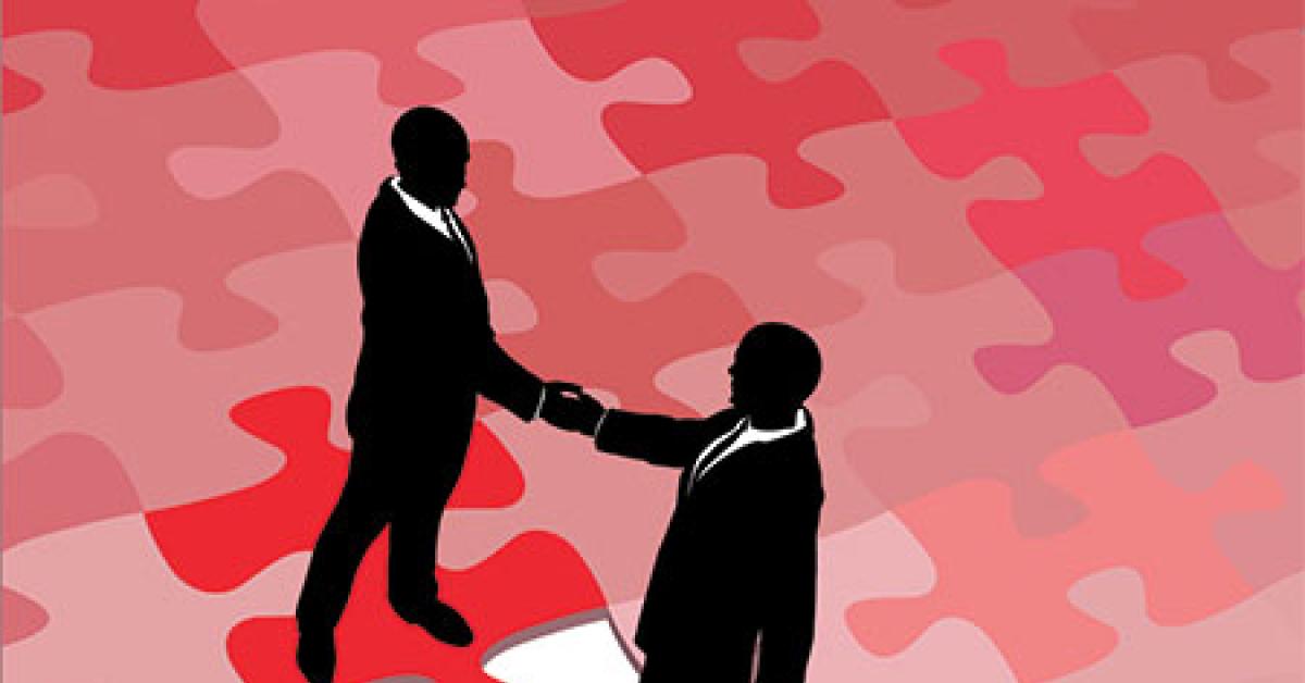 two people shaking hands on puzzle pieces